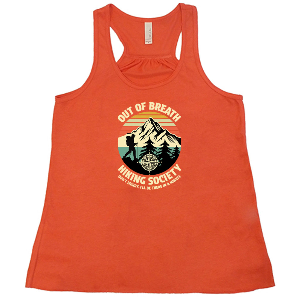 Coral colored flowy tank with a Hiker and mountain graphic on it that says "Out Of Breath Hiking Society"