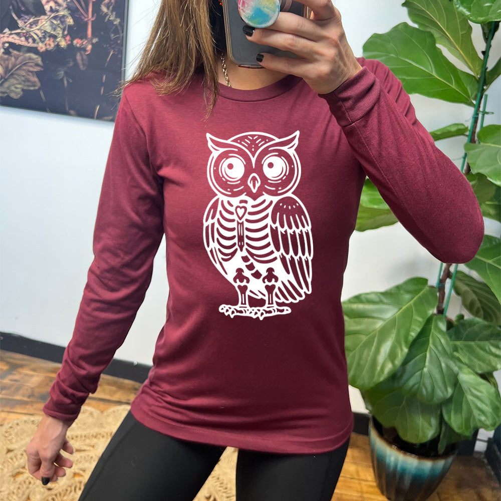 heather cardinal long sleeve tee with the large graphic of an owl with part of its body in skeletal form, with a little heart in the middle of its ribcage
