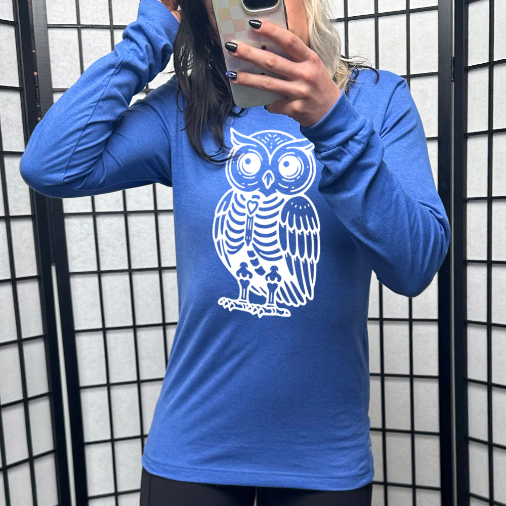 heather true royal long sleeve tee with the large graphic of an owl with part of its body in skeletal form, with a little heart in the middle of its ribcage