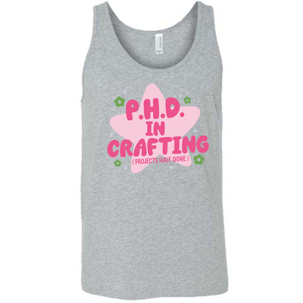 grey unisex tank with cartoon graphic of a large star behind the words "P.H.D. in Crafting" in large font with the words (Projects Half Done) in small font underneath, with very small flowers and stars around