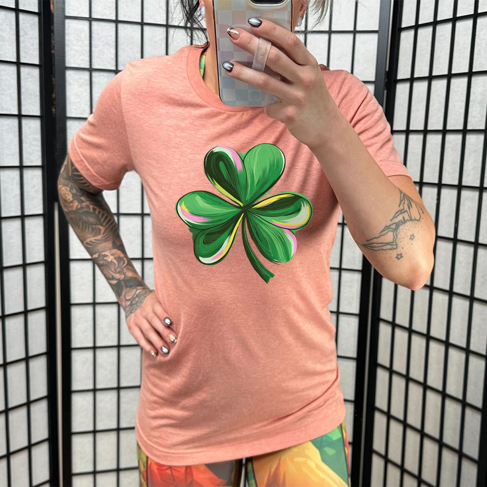 coral shirt with a painted shamrock graphic on it