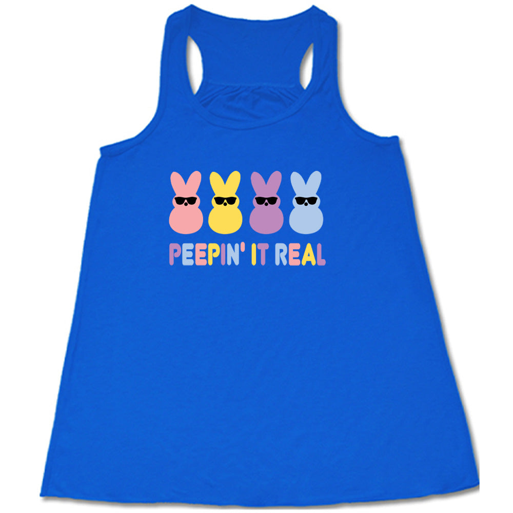 Blue colored flowy tank with an Easter-colored bunnies graphic on it that says "Peepin it Real"