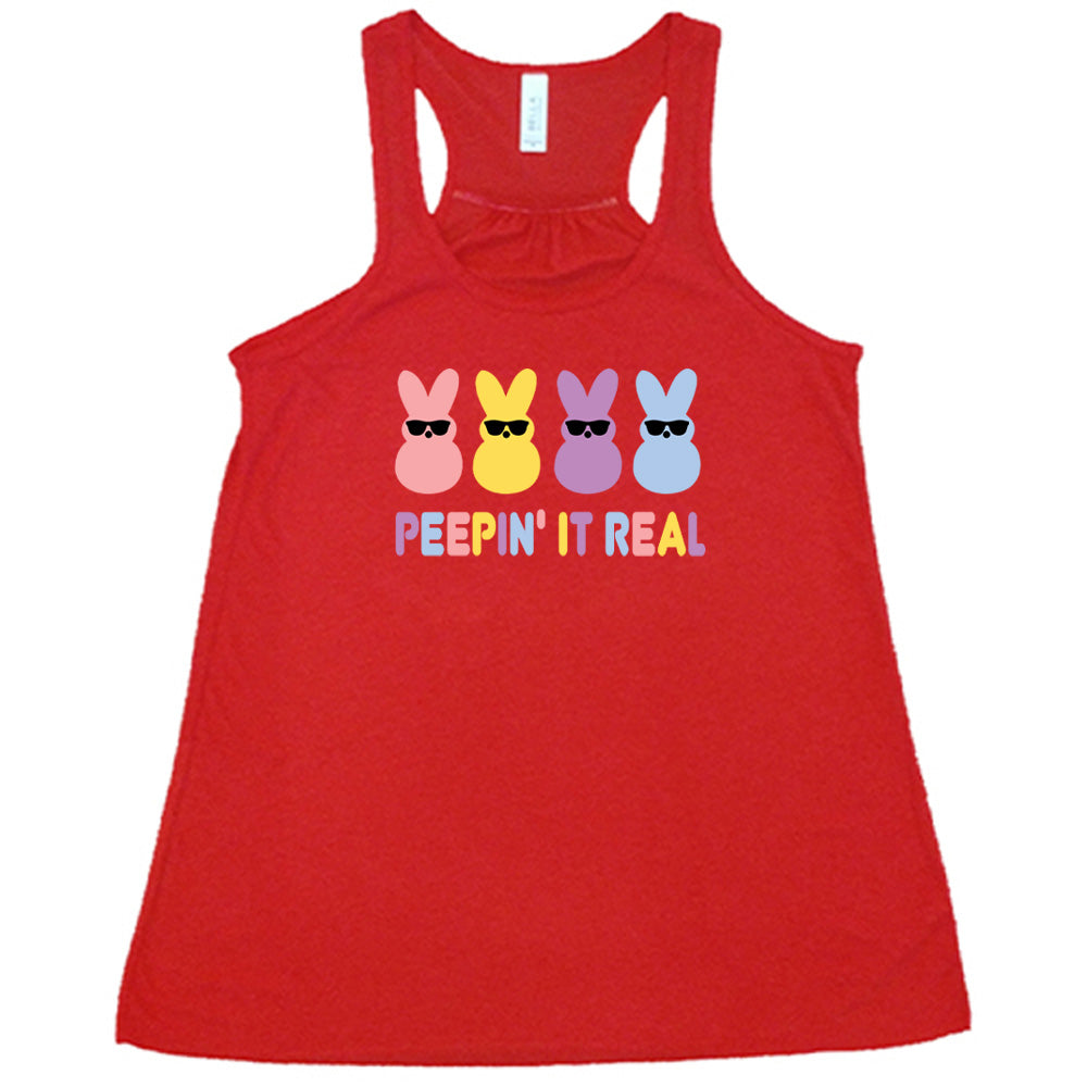 Red colored flowy tank with an Easter-colored bunnies graphic on it that says "Peepin it Real"