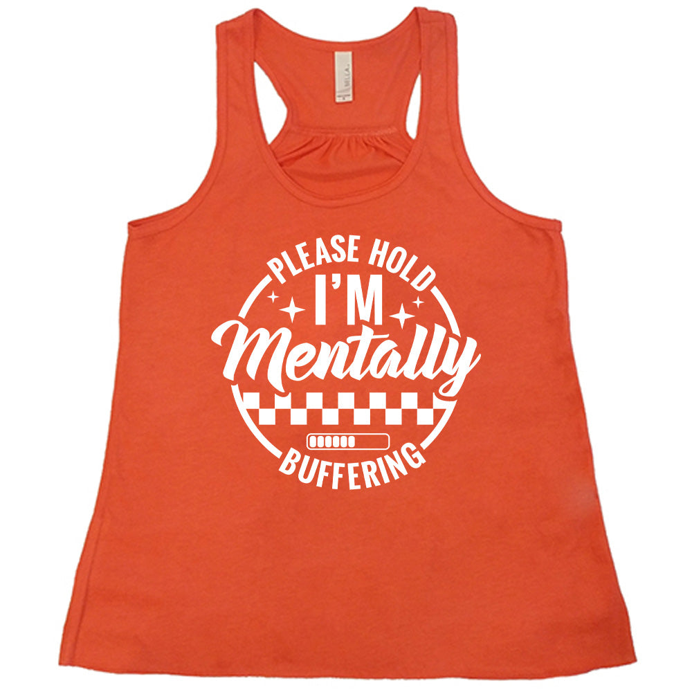 coral racerback flowy tank with the words "please hold I'm mentally buffering" written on it in a circle graphic, with some of the words part of the arches, and within the circle there are two layers of checkerboard as well as a buffering bar, which is about 6 out of 10 full