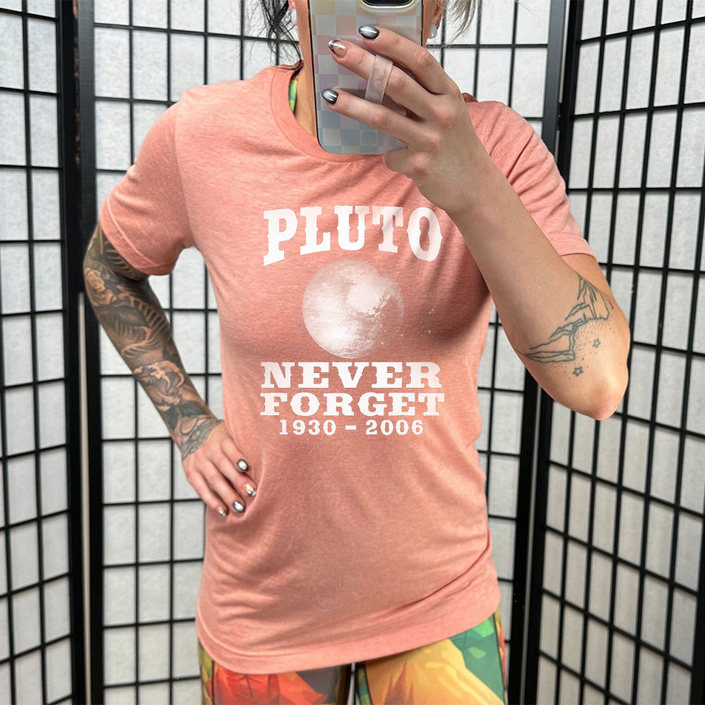 Model wearing sunset colored shirt with a Pluto graphic on it that says "Pluto Never Forget 1930 - 2006"