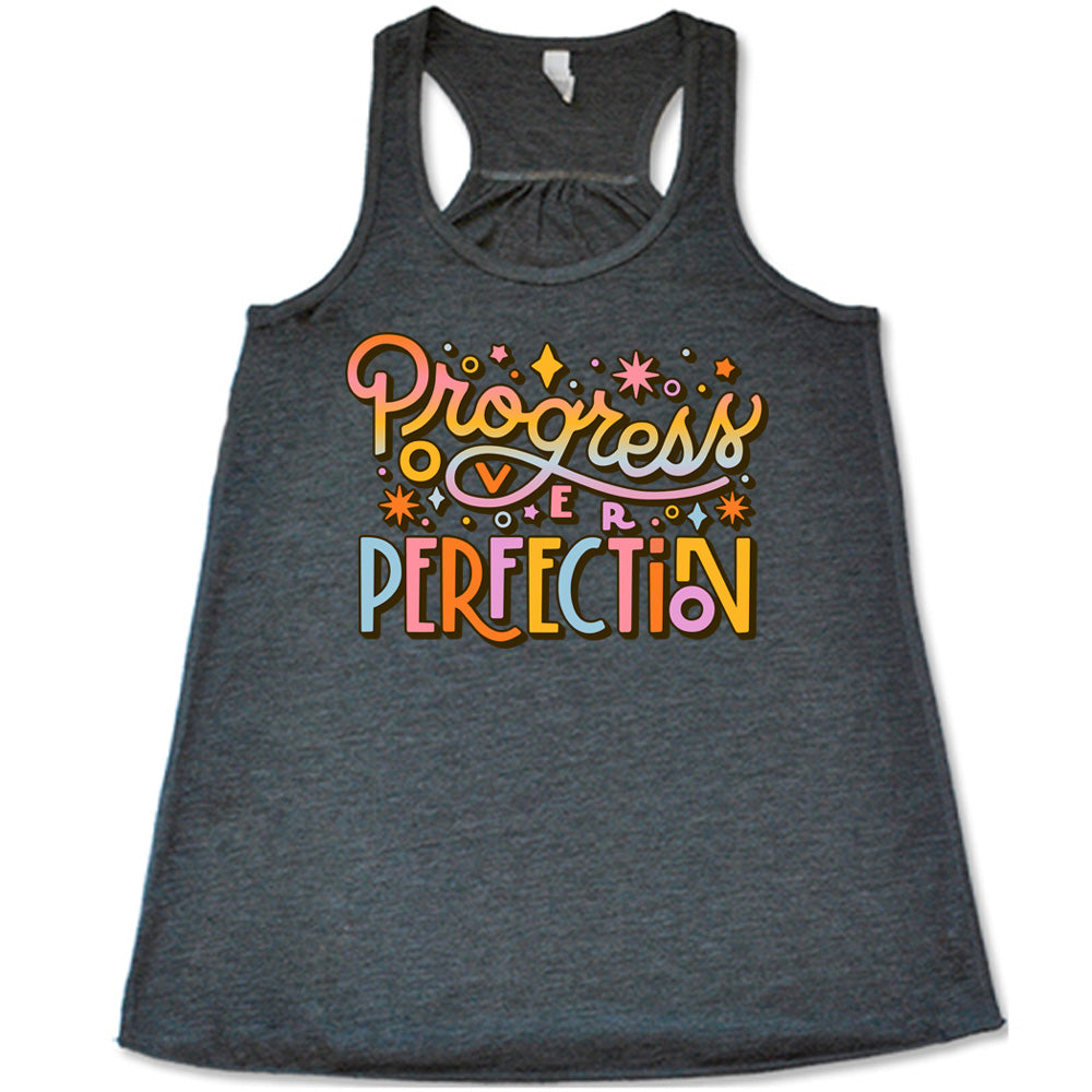 Grey flowy tank with Progress Over Perfection written in colorful lettering, with various stars