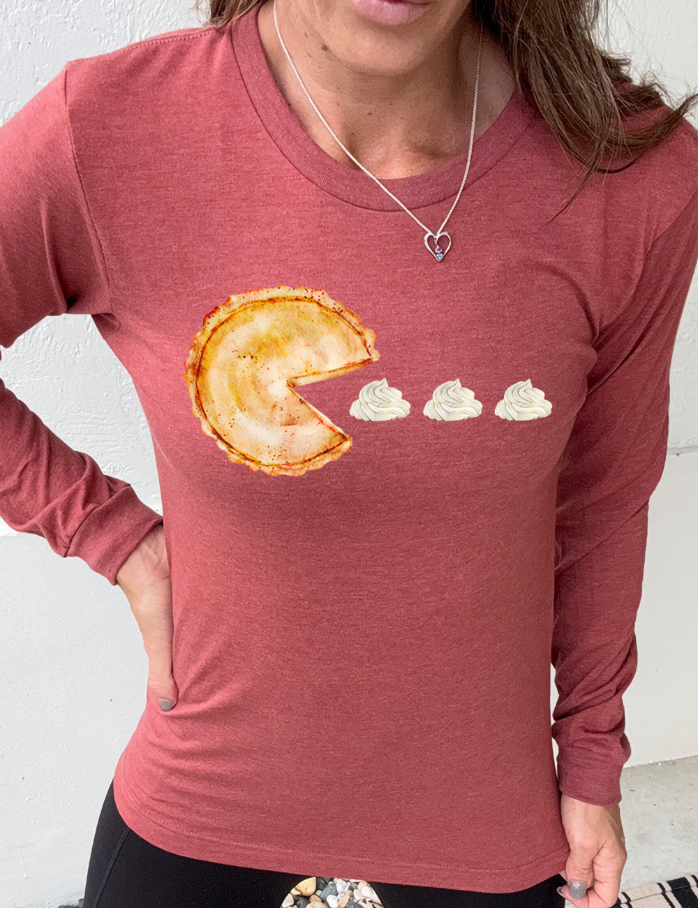 heather clay long sleeve tee with the graphic of a pumpkin pie, with the a slice taken out of it so that it looks like Pacman, heading in the direction of three dollops of whipped cream