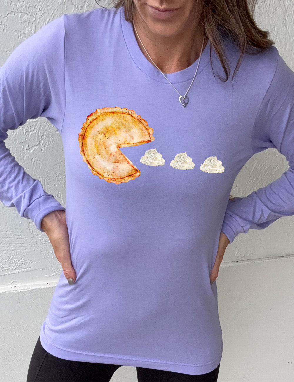 heather dark lavender long sleeve tee with the graphic of a pumpkin pie, with the a slice taken out of it so that it looks like Pacman, heading in the direction of three dollops of whipped cream