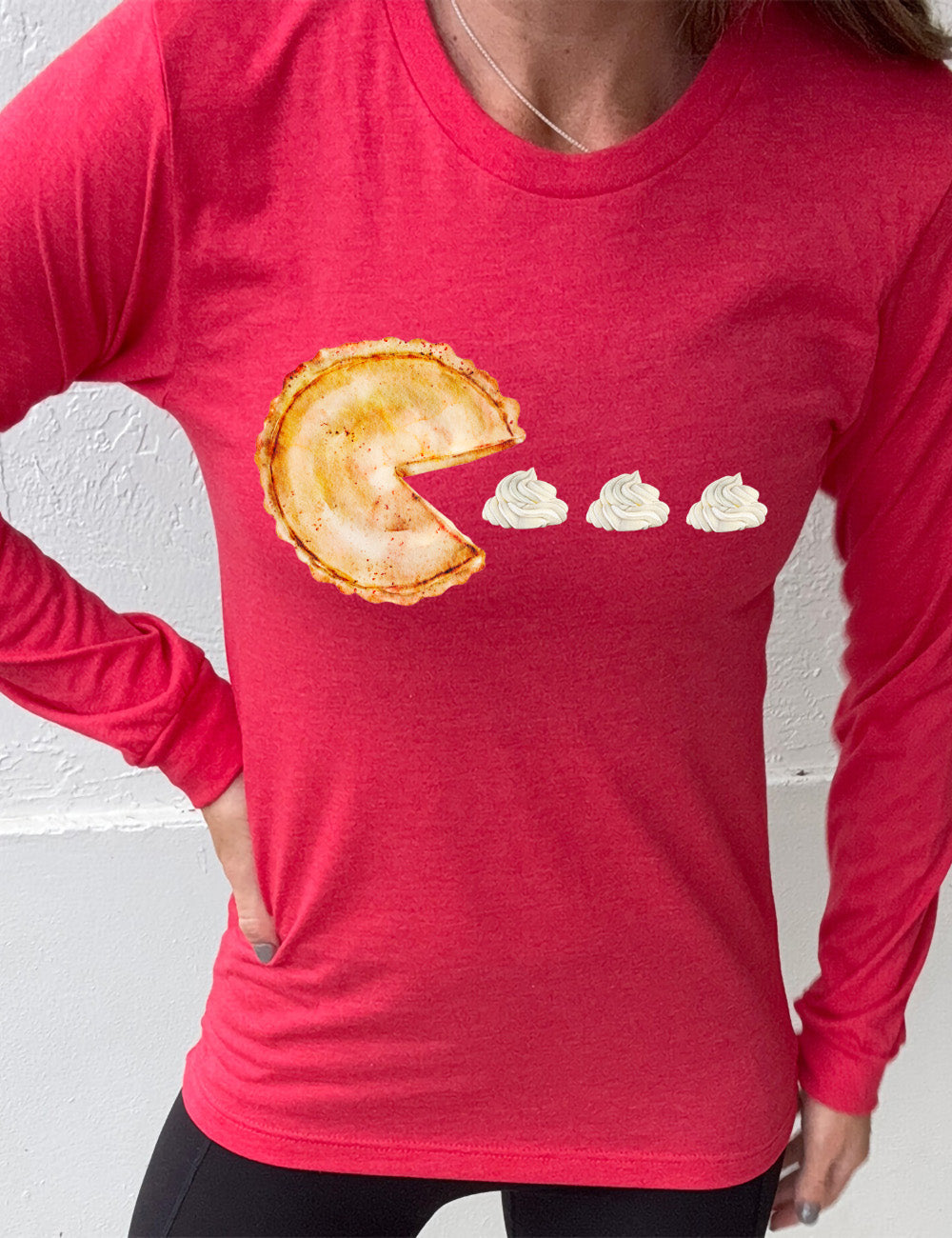heather red long sleeve tee with the graphic of a pumpkin pie, with the a slice taken out of it so that it looks like Pacman, heading in the direction of three dollops of whipped cream
