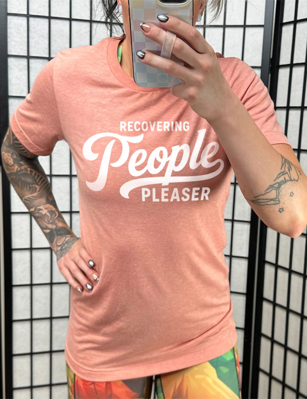 sunset unisex tee with words on it saying "recovering people pleaser"