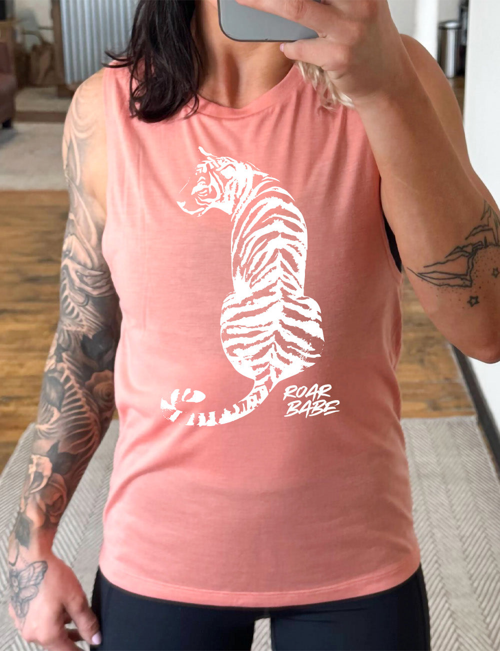 peach muscle tank with the graphic of a tiger, from the back, sitting, looking to one side, with the words "roar babe" in small font underneath
