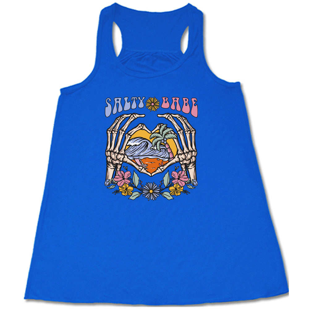 Blue colored flowy tank with a skeleton heart hands around ocean waves graphic on it that says "Salty Babe"
