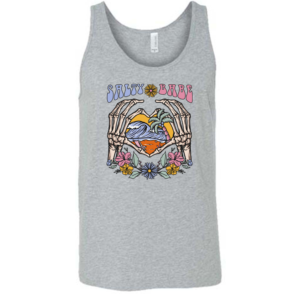 Grey colored tank with a skeleton heart hands around ocean waves graphic on it that says "Salty Babe"