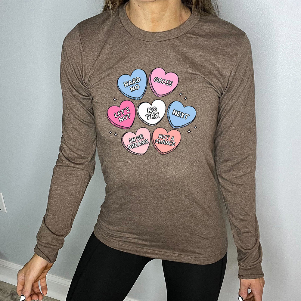 heather brown long sleeve shirt with the graphics of colorful cartoon valentine's heart candies, each saying different things on them: "hard no", "gross", "let's not", "no thx", "next", "in ur dreams", and "not a chance"