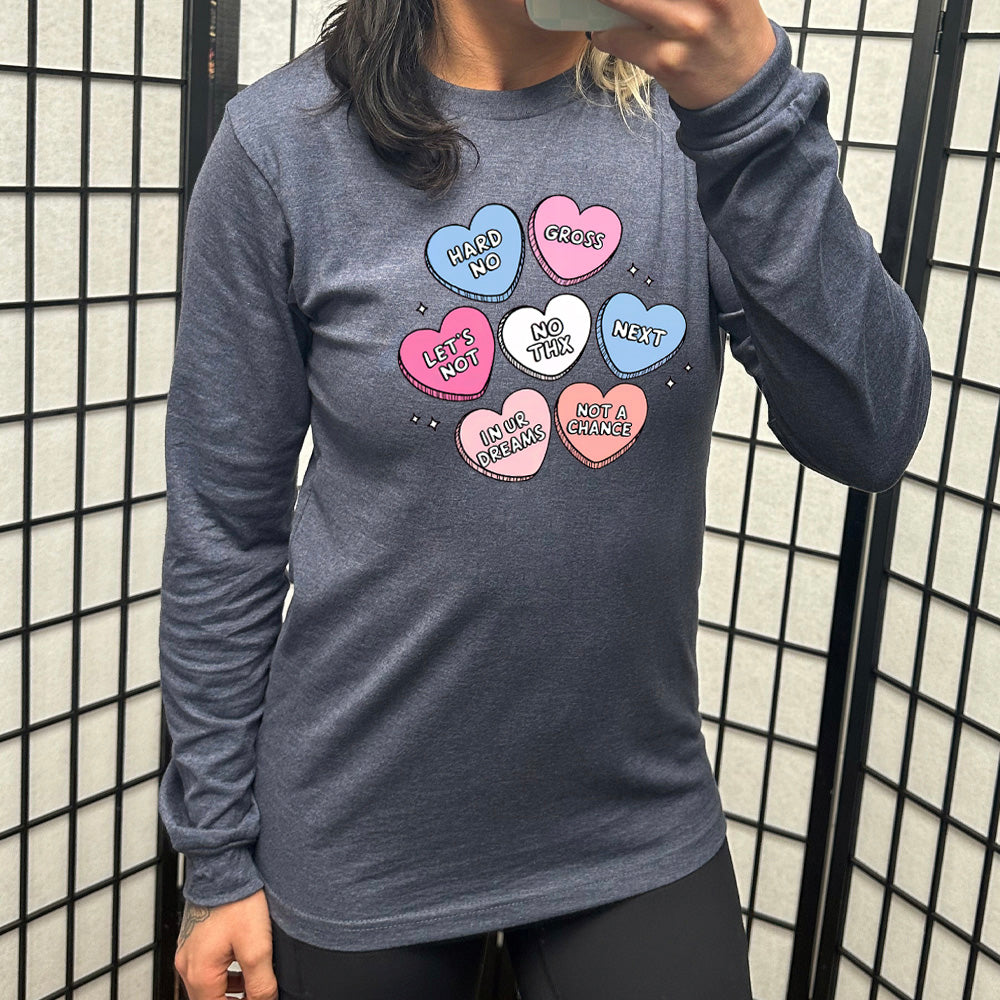heather navy long sleeve shirt with the graphics of colorful cartoon valentine's heart candies, each saying different things on them: "hard no", "gross", "let's not", "no thx", "next", "in ur dreams", and "not a chance"