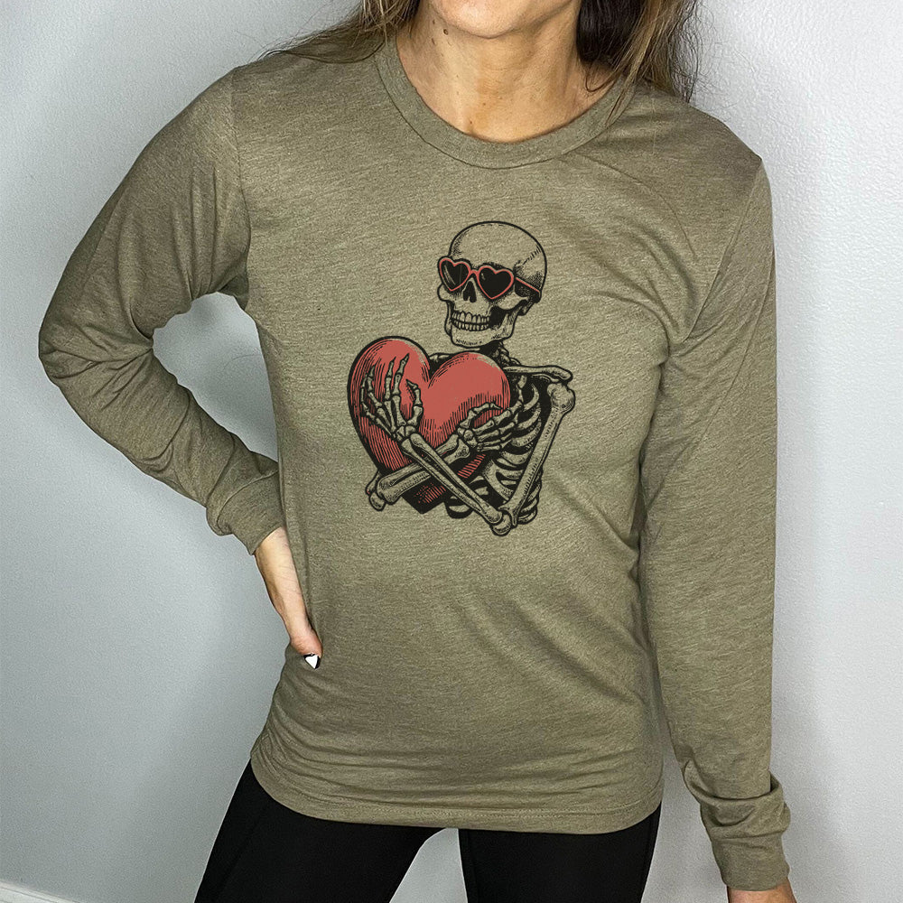 heather olive long sleeve shirt with the graphic of a skeleton, wearing sunglasses, hugging a big heart close