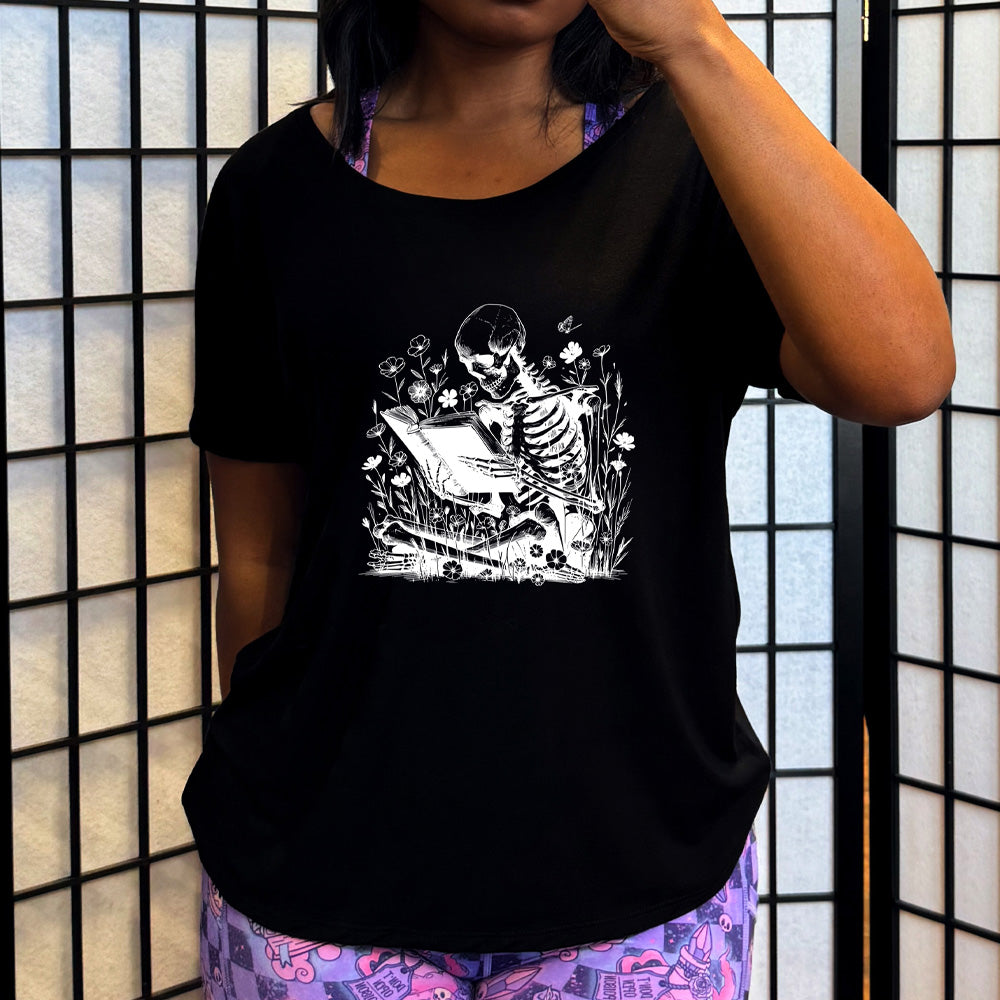 black slouchy shirt with a skeleton reading graphic on it