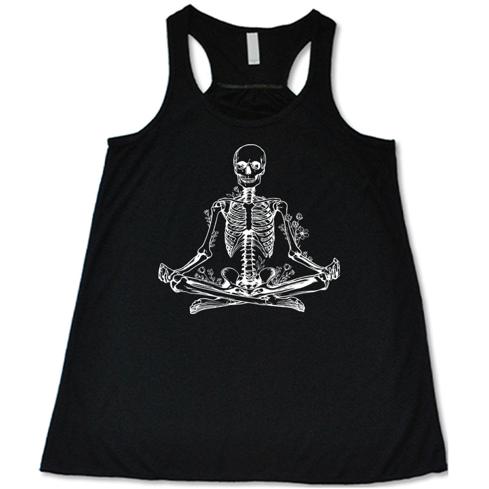 Black flowy tank with a graphic of a skeleton doing a yoga pose, with some flowers growing out of different place on the body
