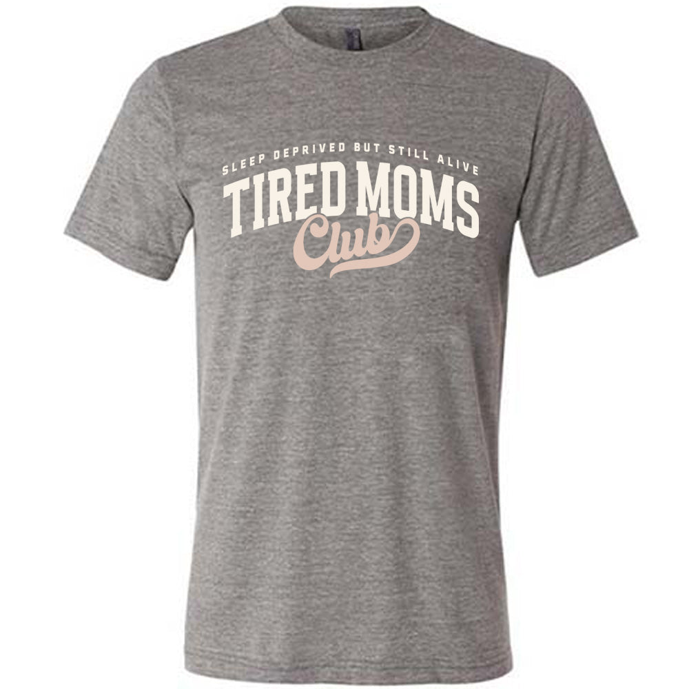 grey unisex tee with the words "sleep deprived but still alive" in smaller letters, and "tired moms club" in large letters