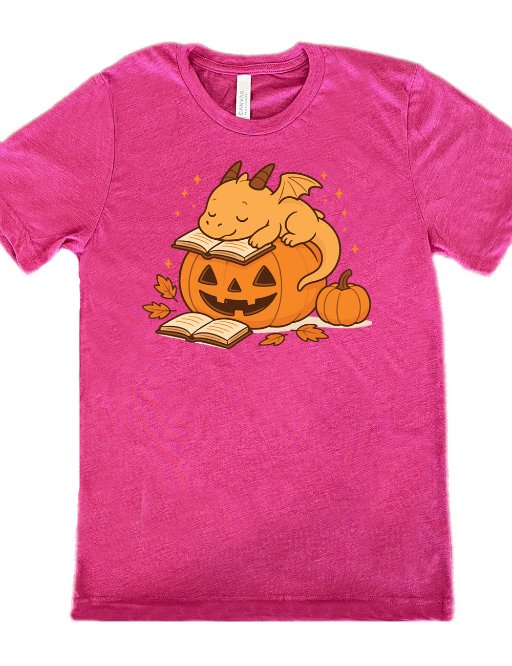 berry unisex tee with the graphic of a cartoon-style dragon sleeping, with its head in its open book, on top of a jack-o-lantern, with another open book and small pumpkin next to all this, and a scattering of stars, and a few leaves