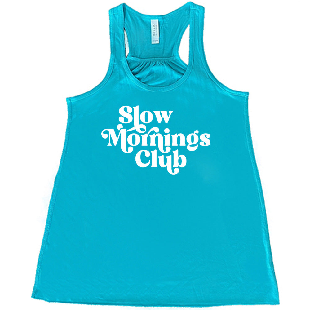 Teal colored flowy tank with a graphic on it that says "Slow Mornings Club"