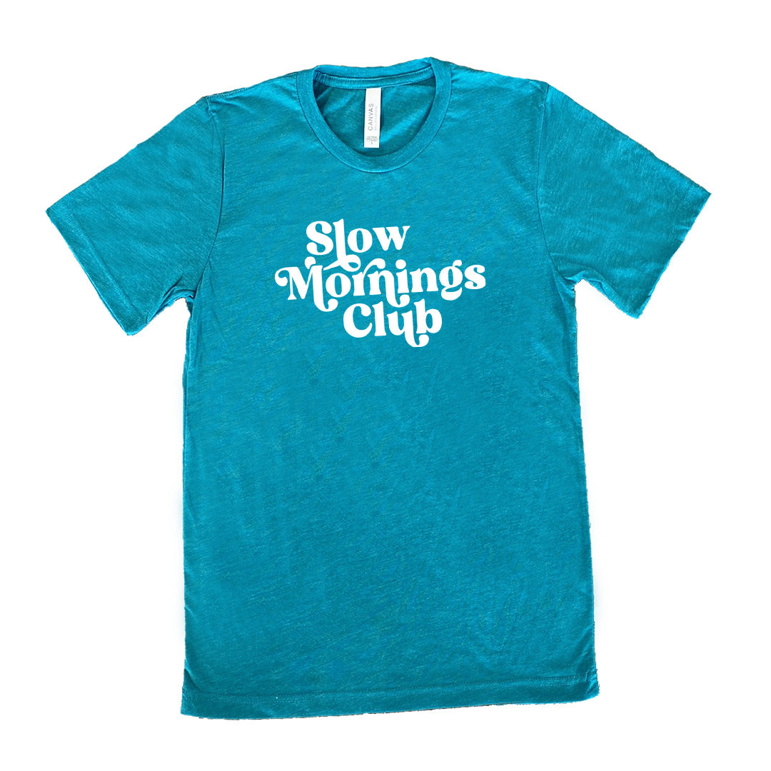 Teal colored shirt with a graphic on it that says "Slow Mornings Club"