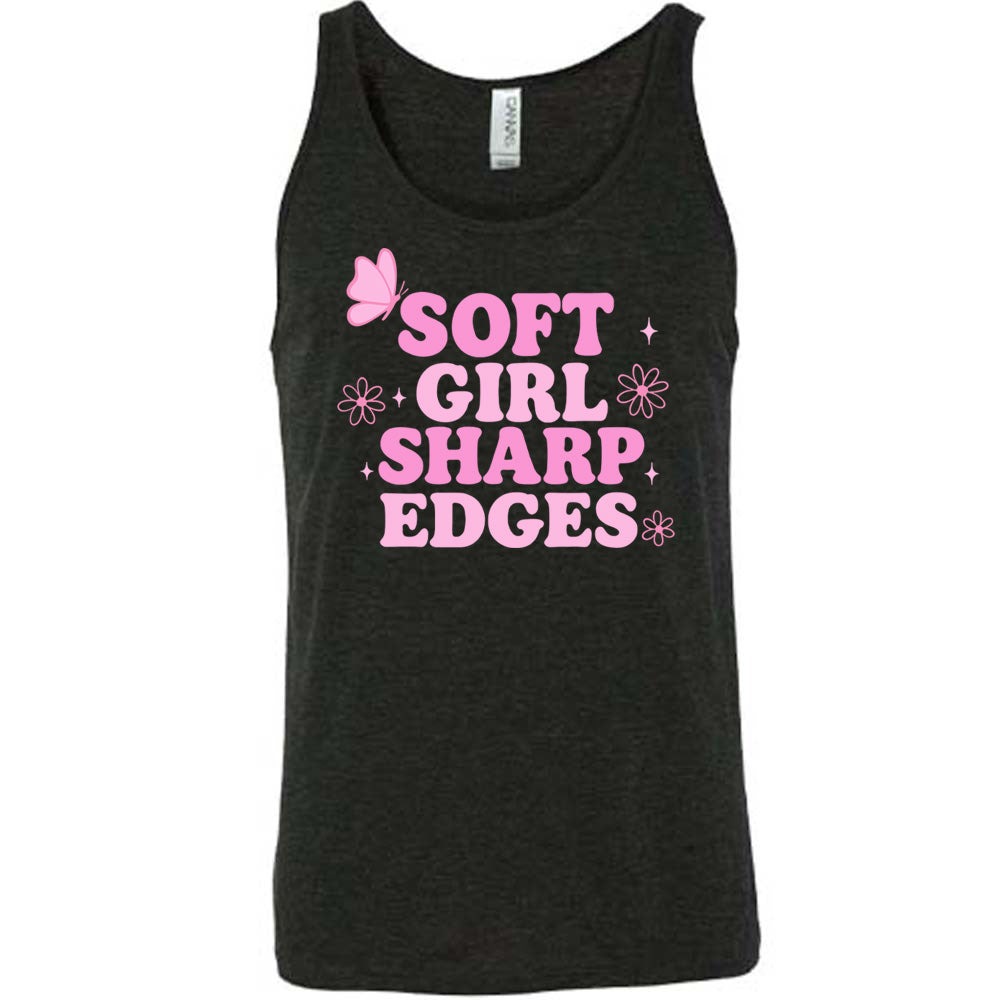 black unisex tank with the words "soft girl sharp edges" in all caps, with graphics of a few little flowers and stars and one butterfly