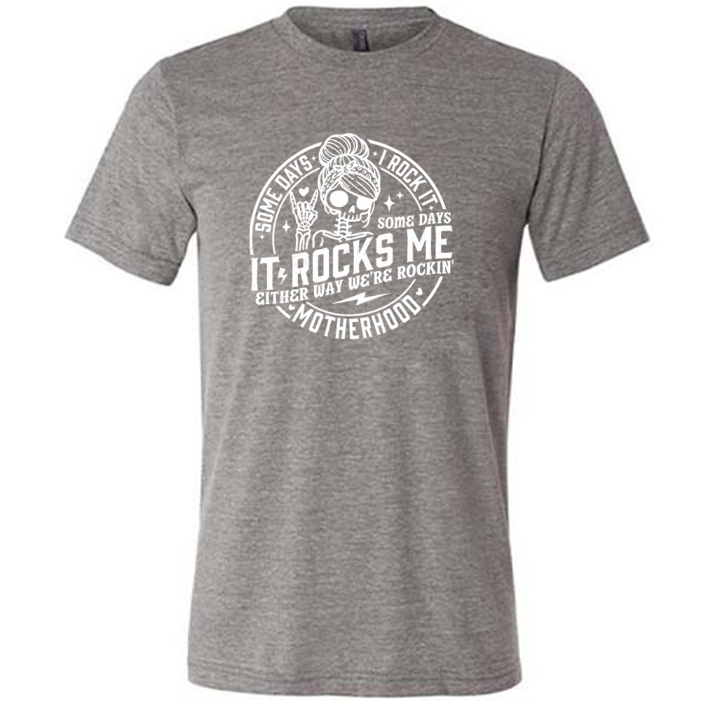 Grey colored shirt with a female skeleton graphic on it that says "Some Days I Rock It Some Days It Rocks Me"