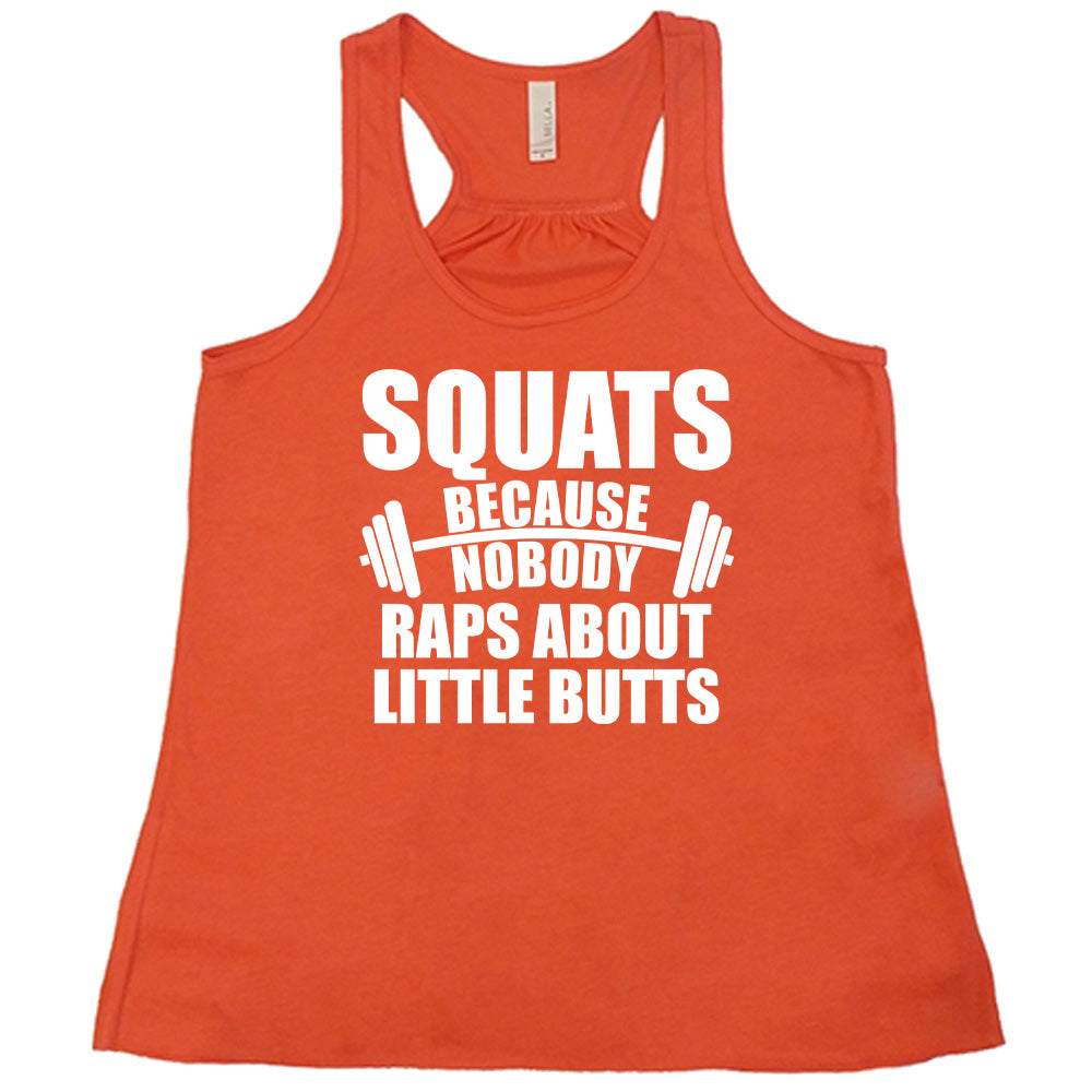 coral flowy tank with the words "squats because nobody raps about little butts" in all caps with a graphic of a barbell between the words "because" and "nobody"