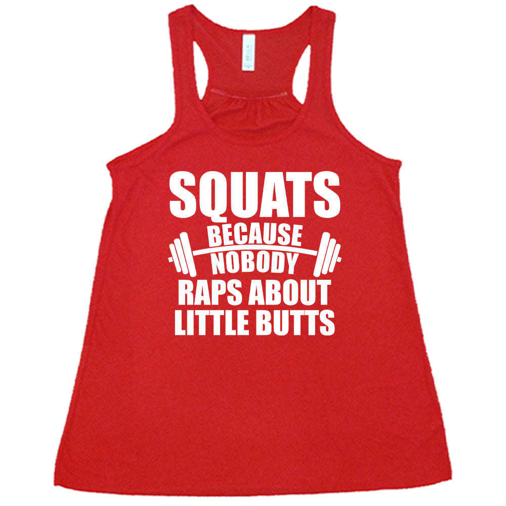 red flowy tank with the words "squats because nobody raps about little butts" in all caps with a graphic of a barbell between the words "because" and "nobody"