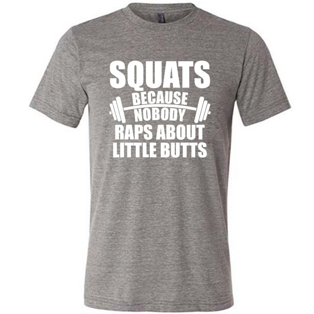 grey unisex tee with the words "squats because nobody raps about little butts" in all caps with a graphic of a barbell between the words "because" and "nobody"