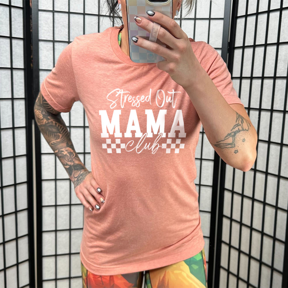 Sunset colored shirt with a graphic on it that says "Stressed Out Mama Club"
