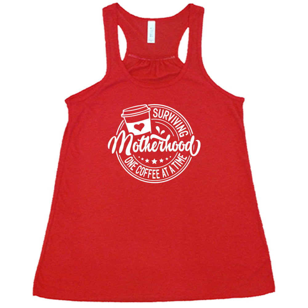 Red colored flowy tank with a coffee cup graphic on it that says "Surviving Motherhood One Coffee at a Time"