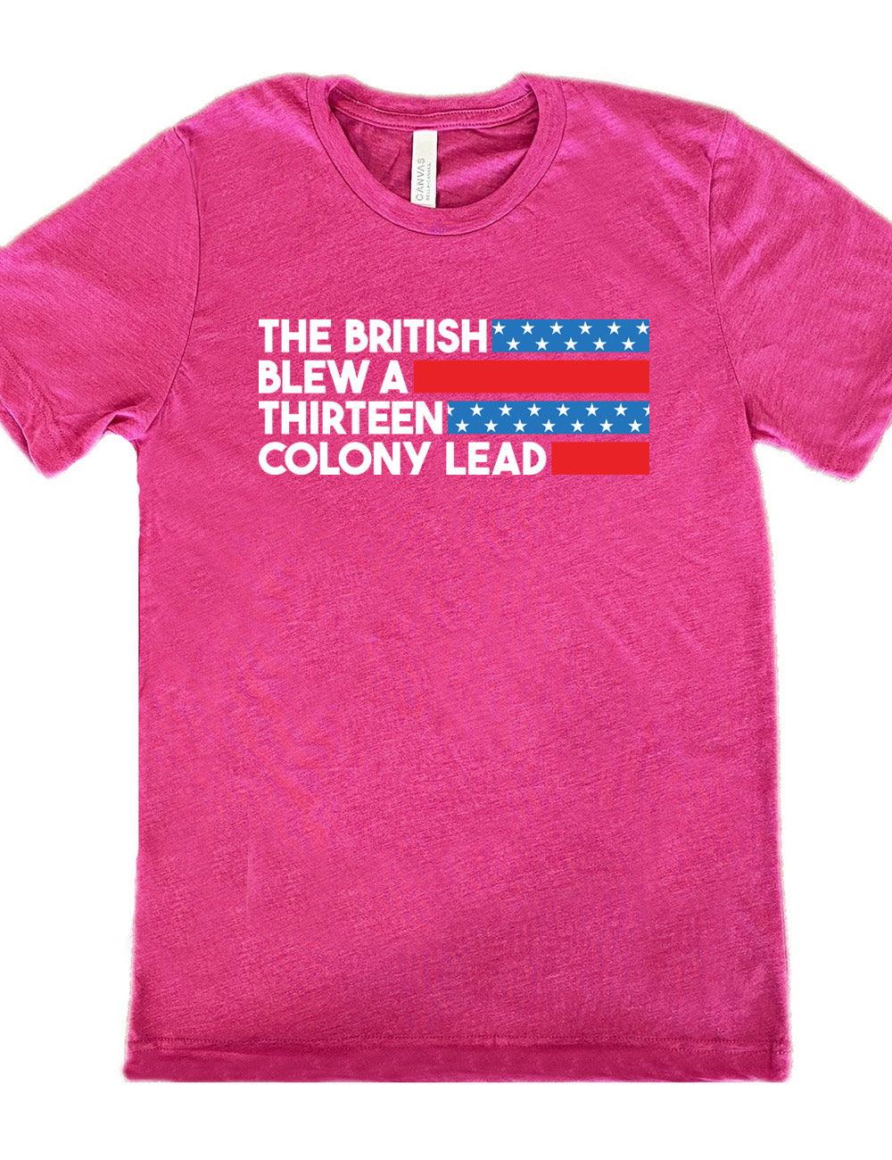 berry unisex tee with the words "the British" (and a blue starred bar finishing the space to the right), then below "blew a" (and a red bar), then below "thirteen" (and a blue starred bar), and below "colony lead" (and a red bar)