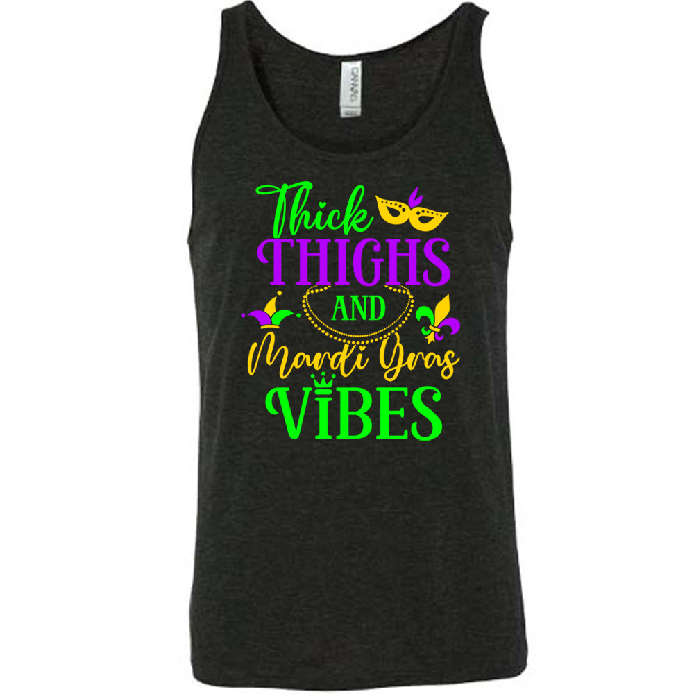 black unisex tank with the words "thick thighs and mardi gras vibes" on it in varying font, with small graphics of mardi gras beads, fleur de lis, a joker hat and a mask