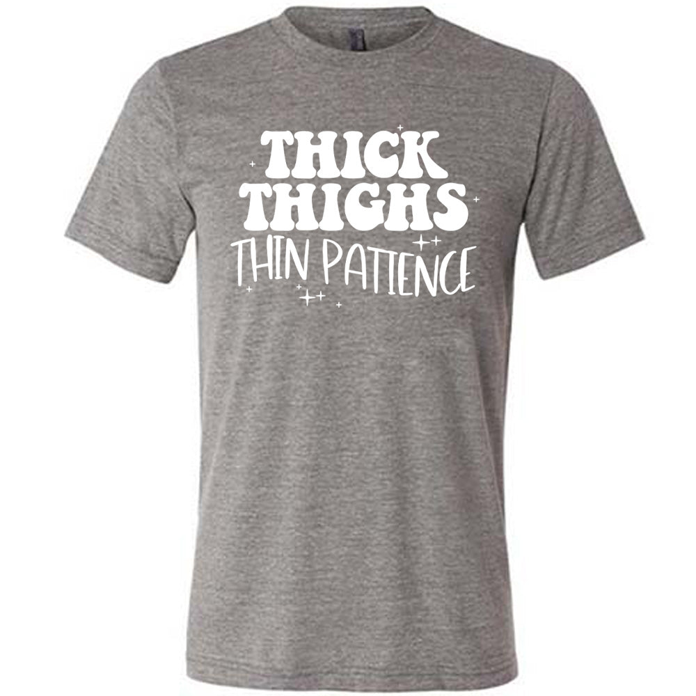 grey unisex tee with the words "thick thighs thin patience" on it, with a few scattered little stars