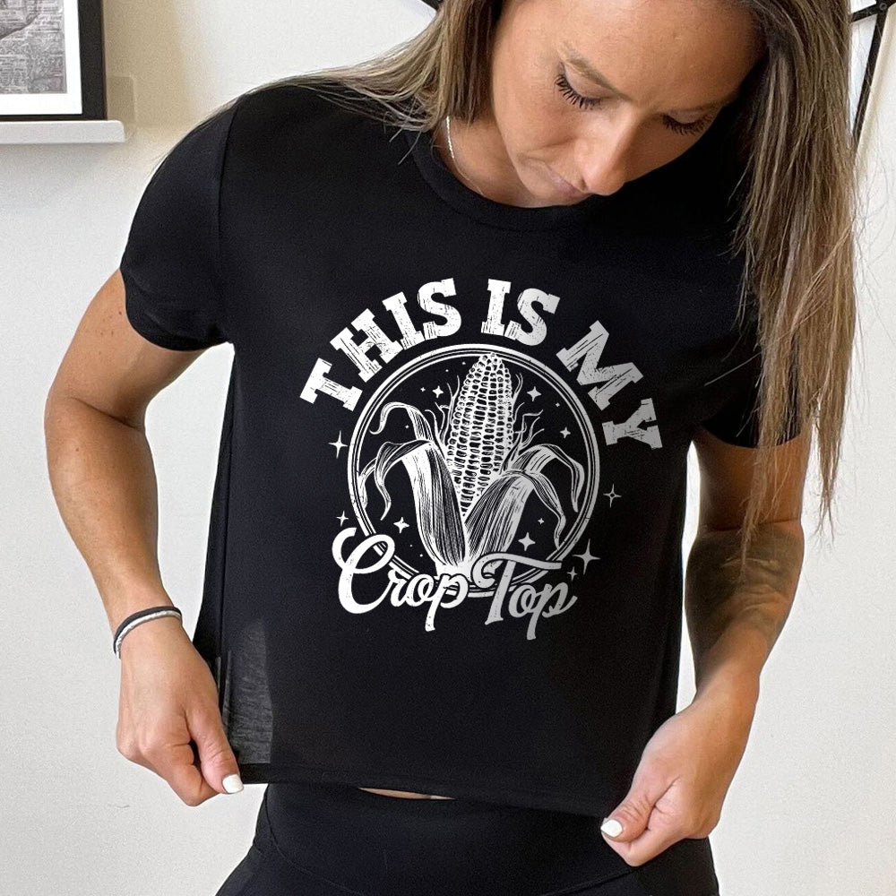 Model wearing black colored cropped tee with corn on the cob graphic on it that says "This Is My Crop Top"