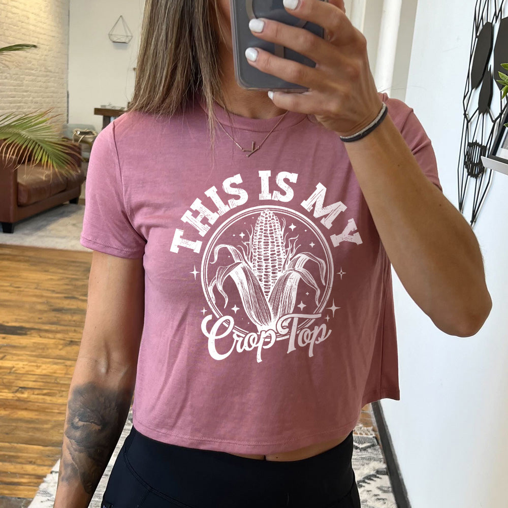 Model wearing mauve colored cropped tee with corn on the cob graphic on it that says "This Is My Crop Top"