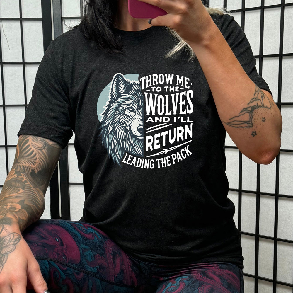 Black colored shirt with a wolf face graphic on it that says "Throw Me To The Wolves And I'll Return Leading the Pack"