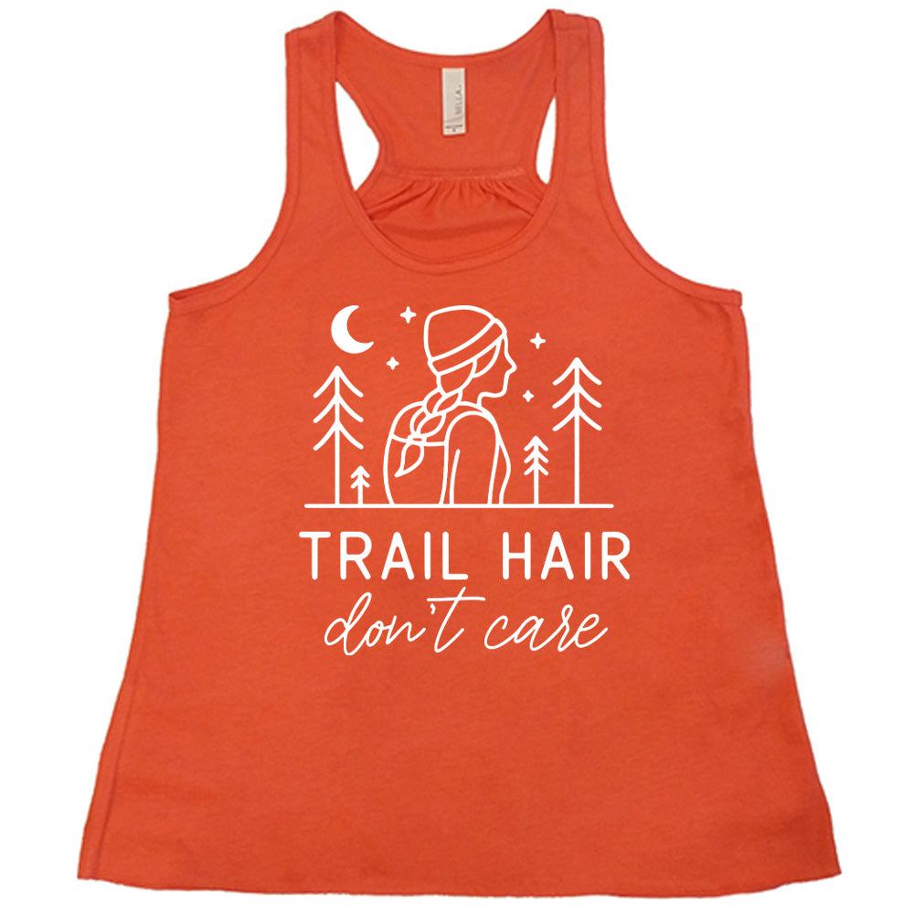 coral flowy tank with the words "trail hair don't care" on it, under the line art graphic of a woman with a hat and braided hair, the moon and stars, and four trees