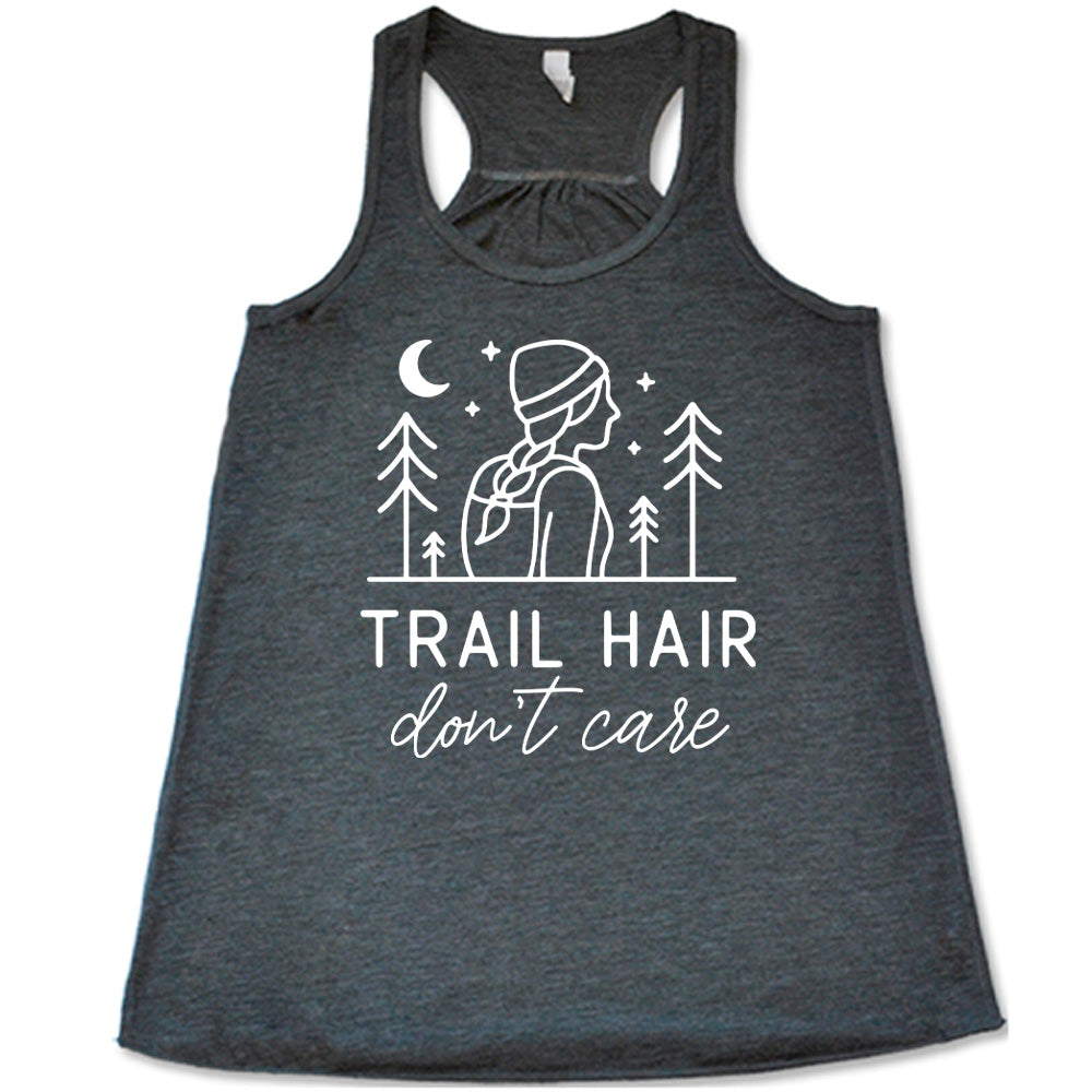 grey flowy tank with the words "trail hair don't care" on it, under the line art graphic of a woman with a hat and braided hair, the moon and stars, and four trees