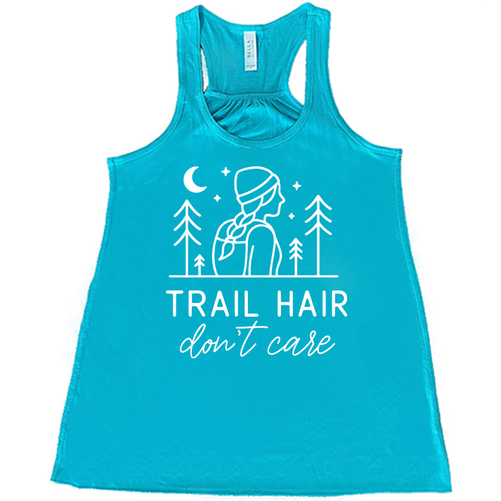 teal flowy tank with the words "trail hair don't care" on it, under the line art graphic of a woman with a hat and braided hair, the moon and stars, and four trees