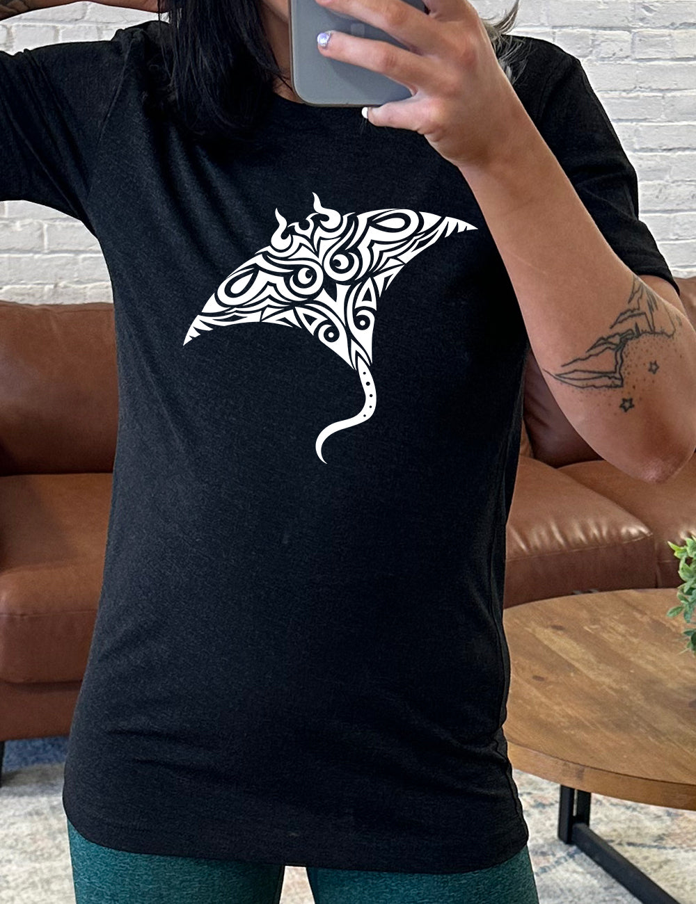 black unisex tee with the graphic of a manta ray in tribal design