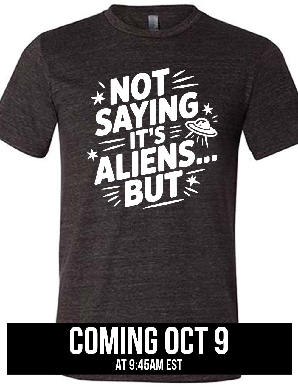 black unisex tee with words, embellished by line graphics, saying "not saying it's aliens...but" with graphics of little stars and an alien spaceship, coming October 9th