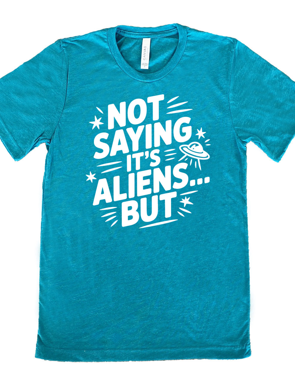 teal unisex tee with words, embellished by line graphics, saying "not saying it's aliens...but" with graphics of little stars and an alien spaceship