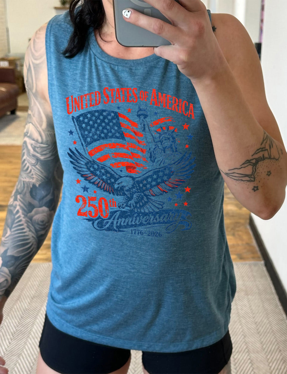 deep teal muscle tank with the graphic of the eagle, wings spread, the statue of liberty, and an American flag, and lots of little stars, and the words saying "United Stated of America 250th Anniversary 1776-2026"