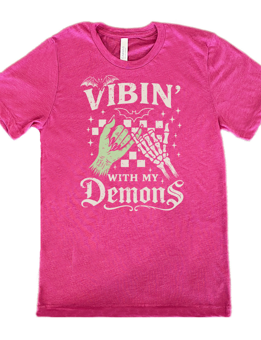 berry unisex tee with words saying "Vibin' with my Demons", around the graphic of the hands of a zombie and a skeleton doing a pinky promise, in front of a checkered background, and one line-drawn bat and one detailed bat on top, and scattered stars