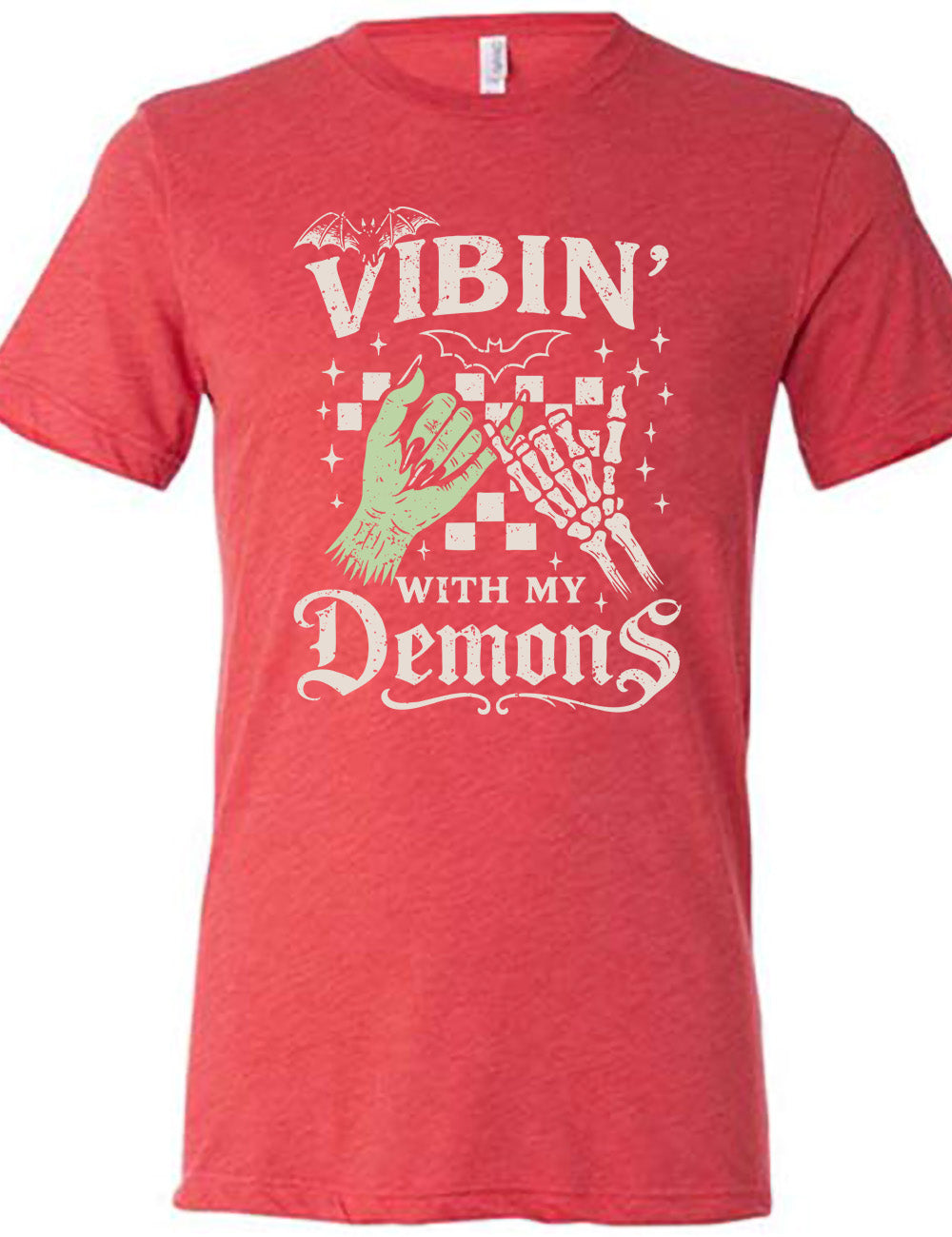 red unisex tee with words saying "Vibin' with my Demons", around the graphic of the hands of a zombie and a skeleton doing a pinky promise, in front of a checkered background, and one line-drawn bat and one detailed bat on top, and scattered stars