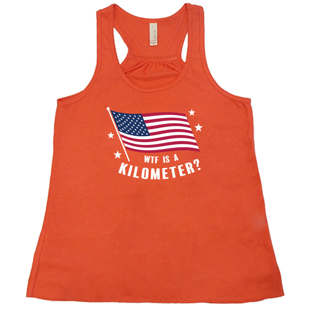 Coral colored flowy tank with an American flag graphic on it that says "WTF Is A Kilometer?"