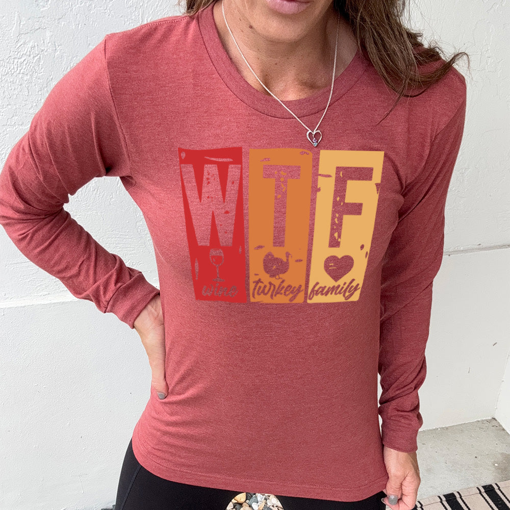 heather clay long sleeve shirt with a graphic on it that says "WTF" and under the "W" there's a graphic of a wine glass and the word "wine"; under "T" there's a graphic of a turkey and the word "turkey"; under F there's a graphic of a heart and the word "family"
